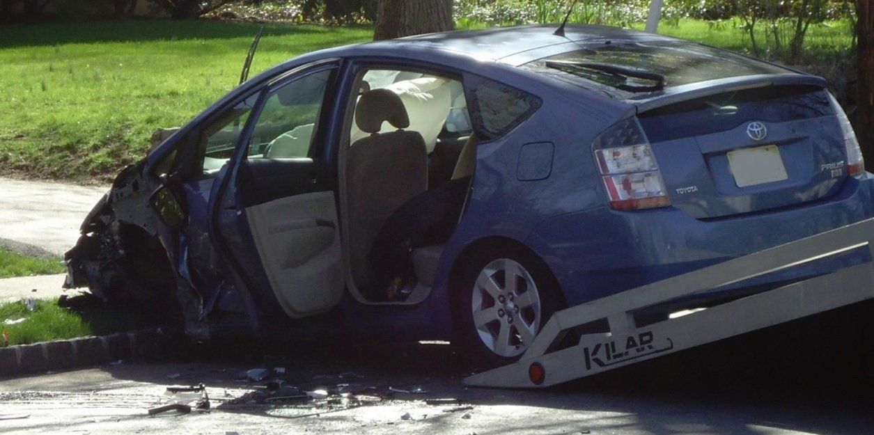 A blue car is sitting on top of a tow truck.