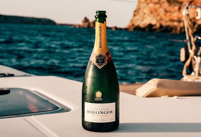 A bottle of champagne is sitting on the deck of a boat.
