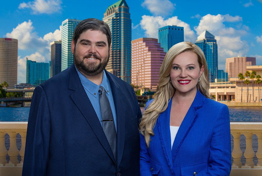 A man and a woman are posing for a picture in front of a city skyline. - Tampa, Fl - J.h. Williams Oil Company Incorporated
