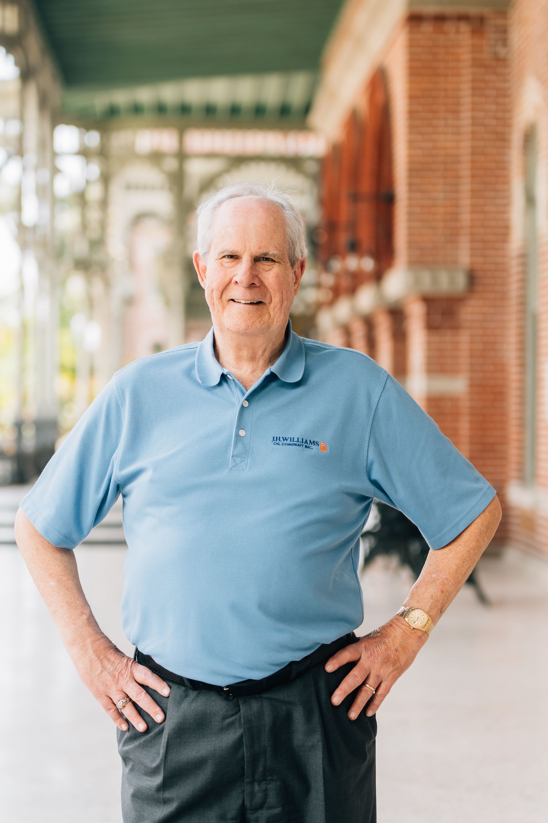 A man in a blue shirt is standing with his hands on his hips. A man in a blue shirt is standing with his hands on his hips.