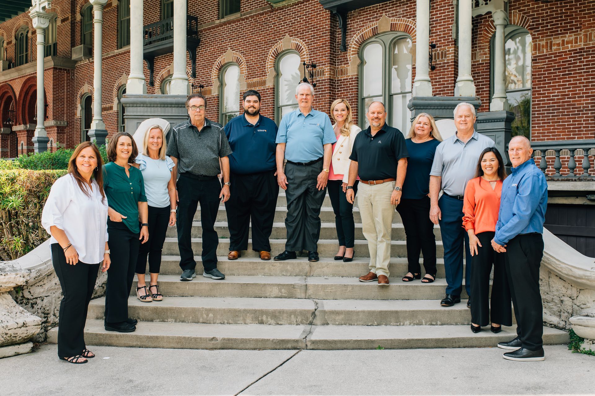 A group of people are standing in front of a building. A group of people are standing in front of a building.