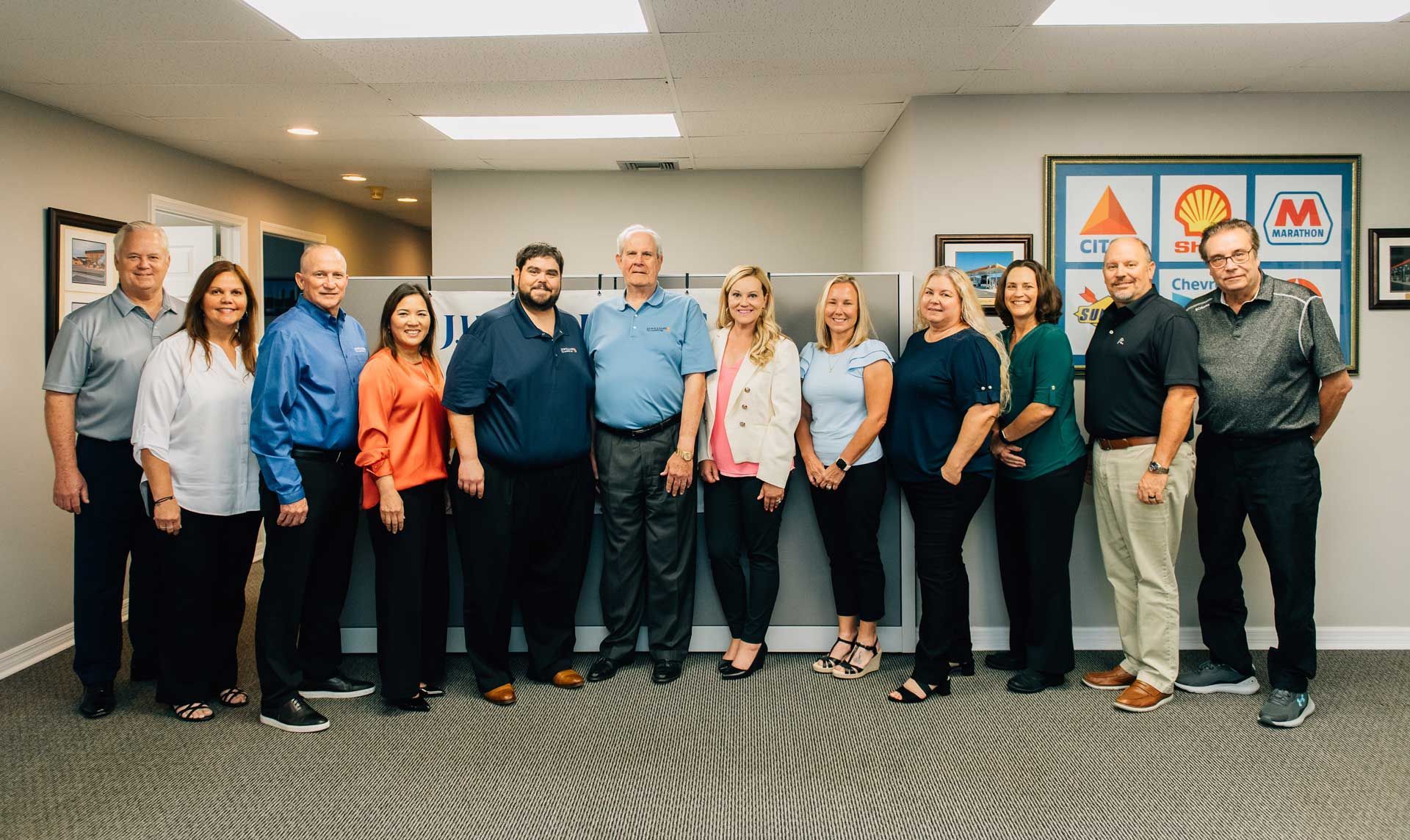 A group of people are posing for a picture in an office. A group of people are posing for a picture in an office.