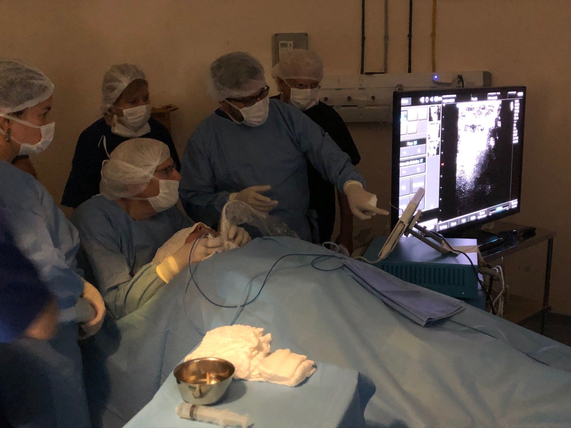 A group of surgeons are working on a patient in an operating room