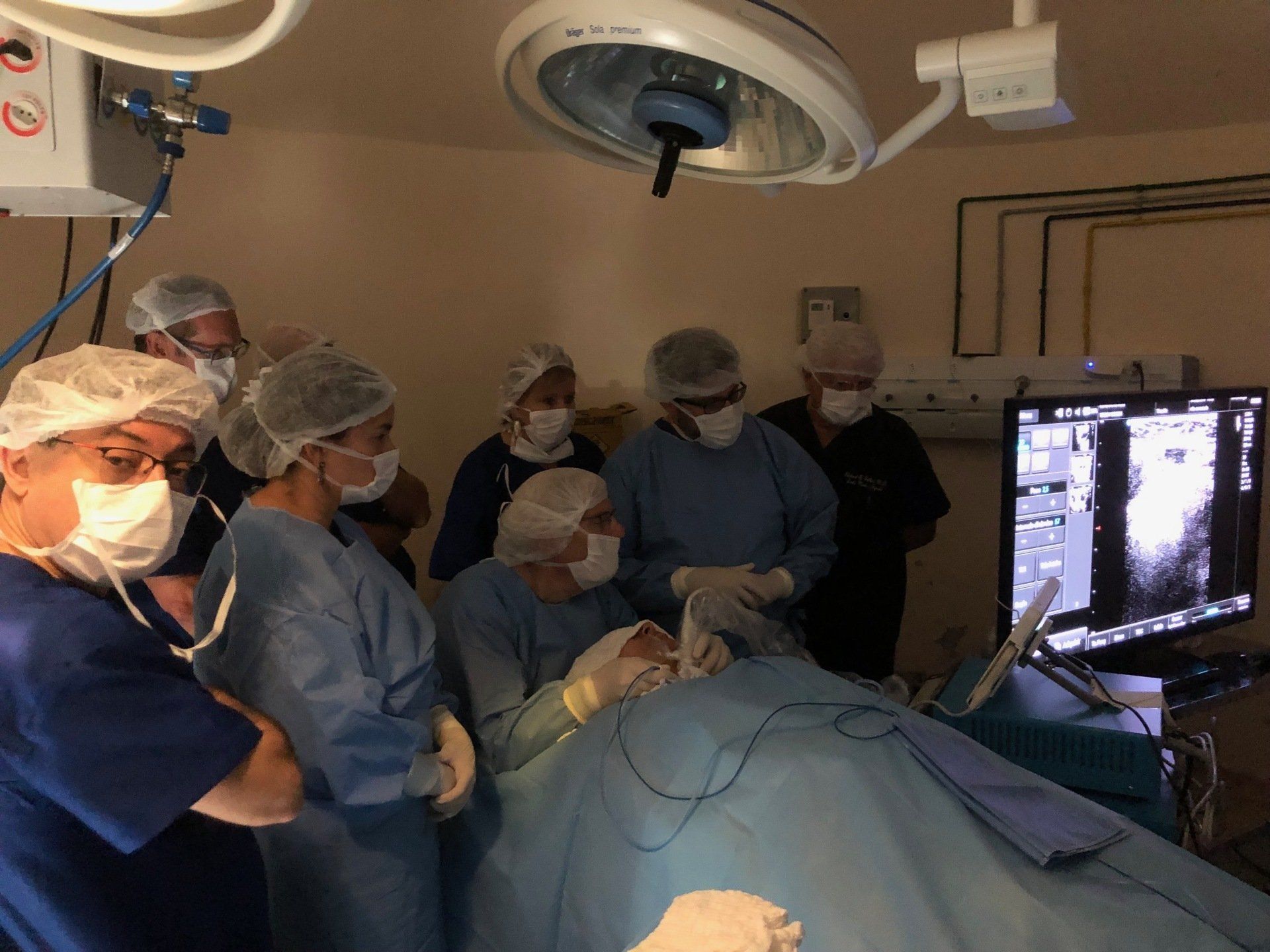 A group of surgeons are working on a patient in an operating room