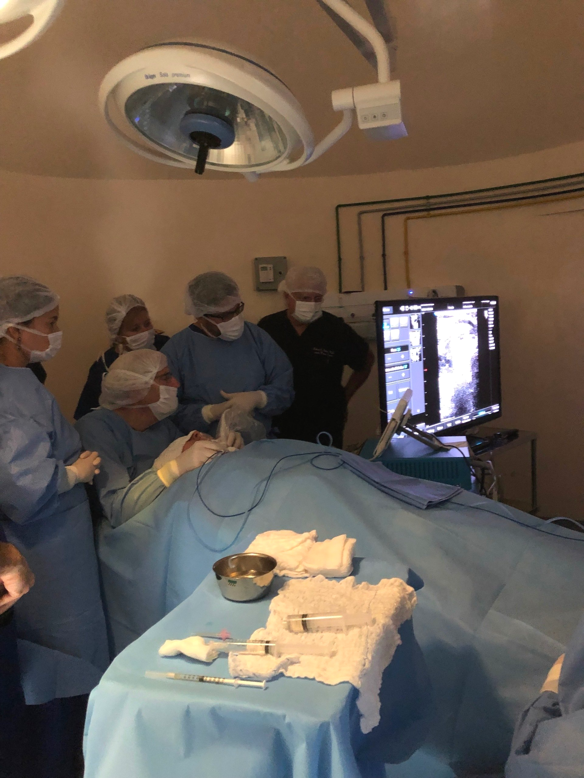 A group of surgeons are working on a patient in an operating room
