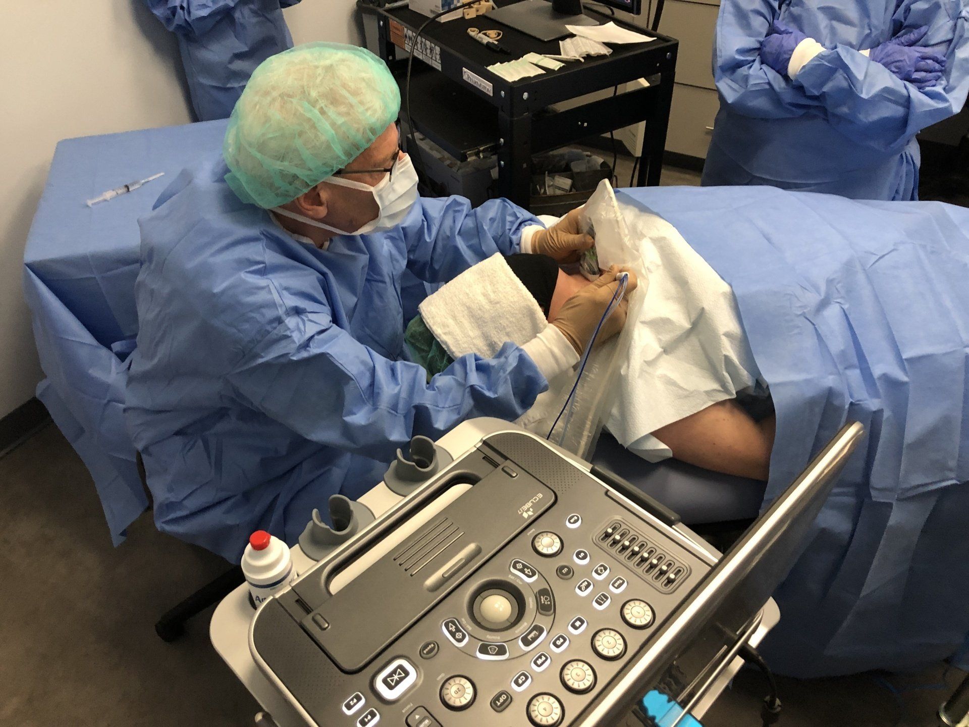 A surgeon is working on a patient in an operating room.