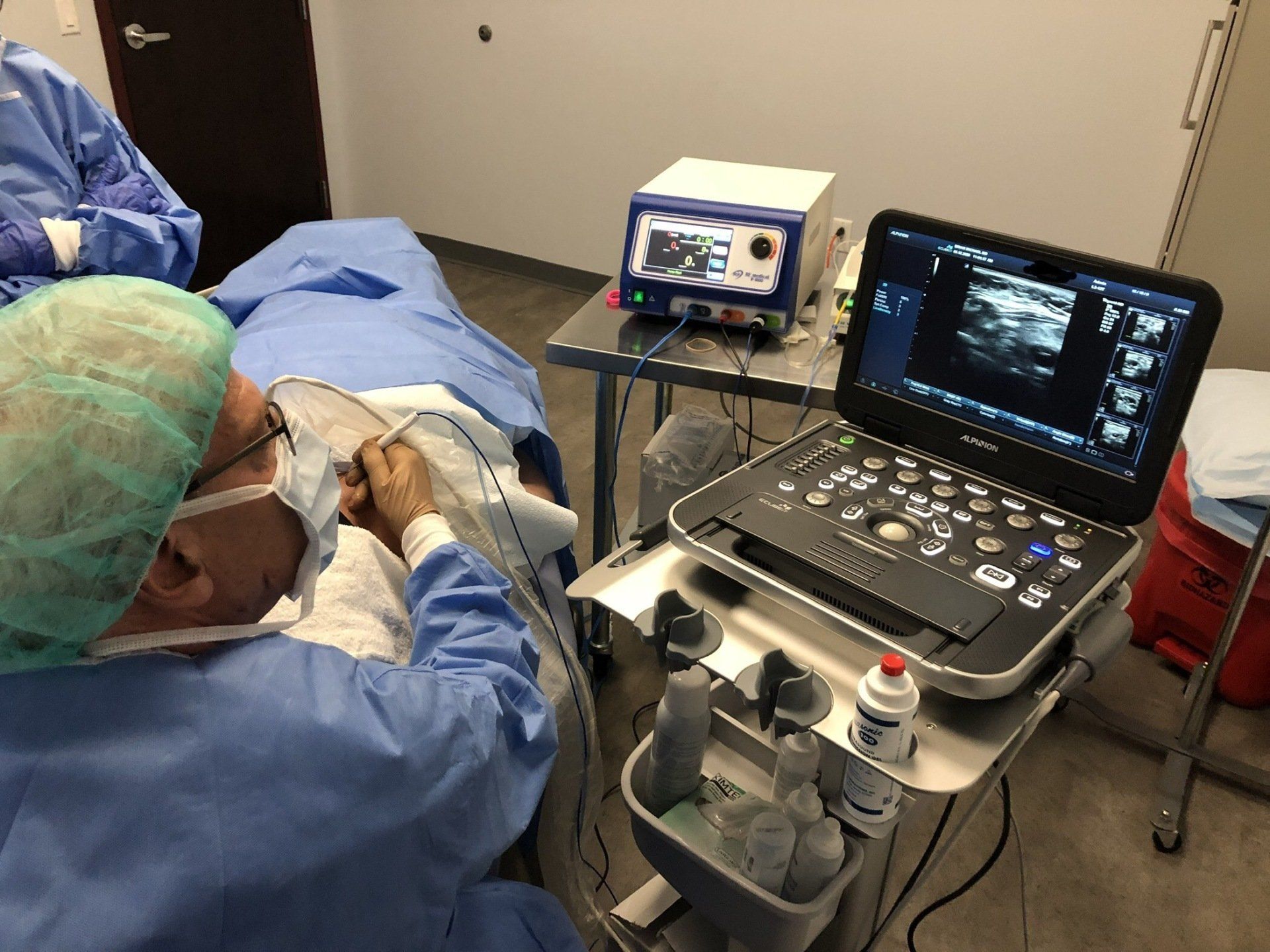 A surgeon is using an ultrasound machine on a patient.