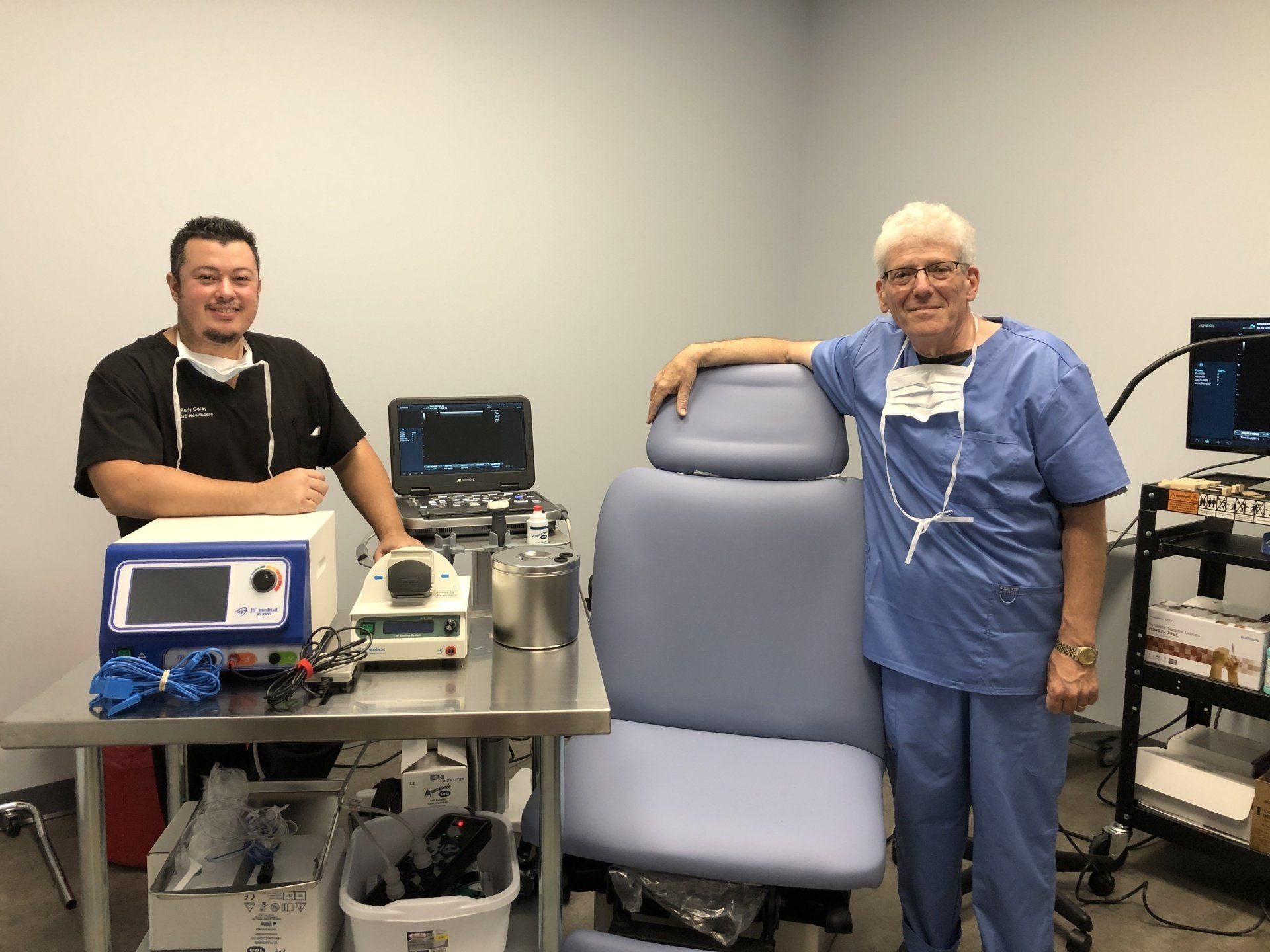 Two doctors are standing next to each other in a hospital room.