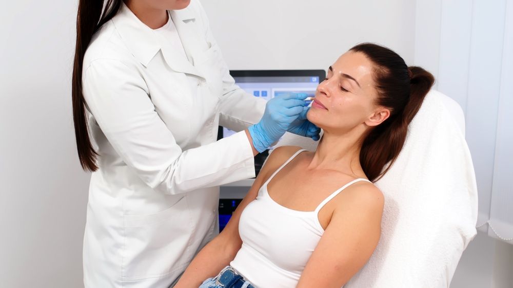 Woman receiving lip injection from a doctor in a medical setting.