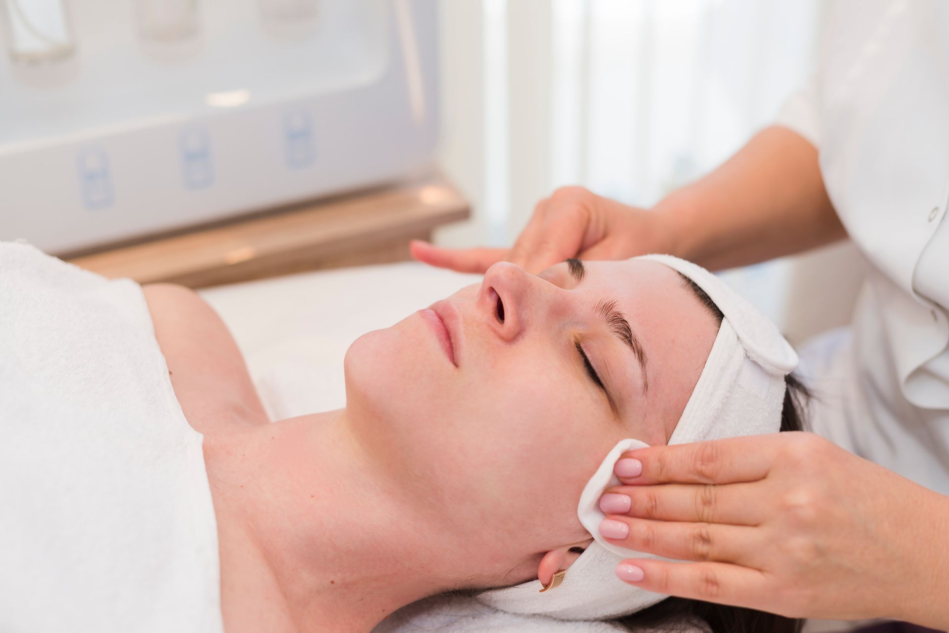 A woman is getting a facial treatment at a spa.
