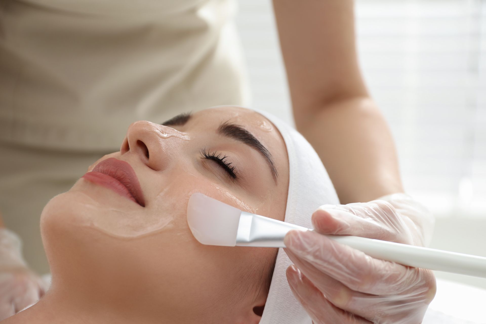 A woman is getting a facial treatment at a beauty salon.