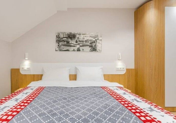 A bedroom with a bed and a painting on the wall