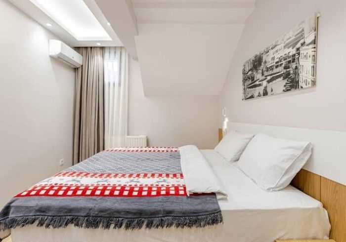 A bedroom with a bed and a picture on the wall.