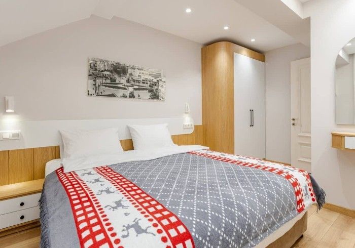 A bedroom with a large bed and a picture on the wall above it.