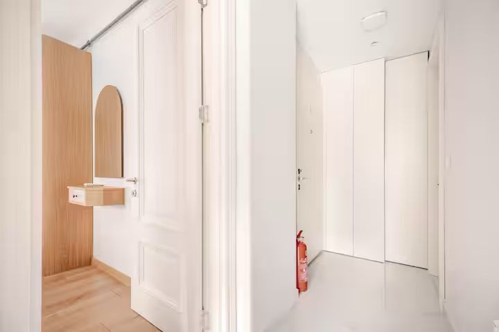 There is a fire extinguisher in the hallway next to the door.