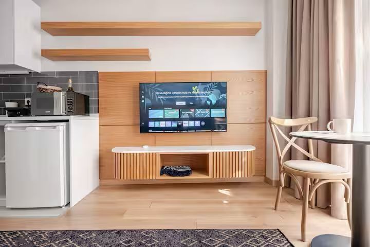 A living room with a flat screen tv on the wall.