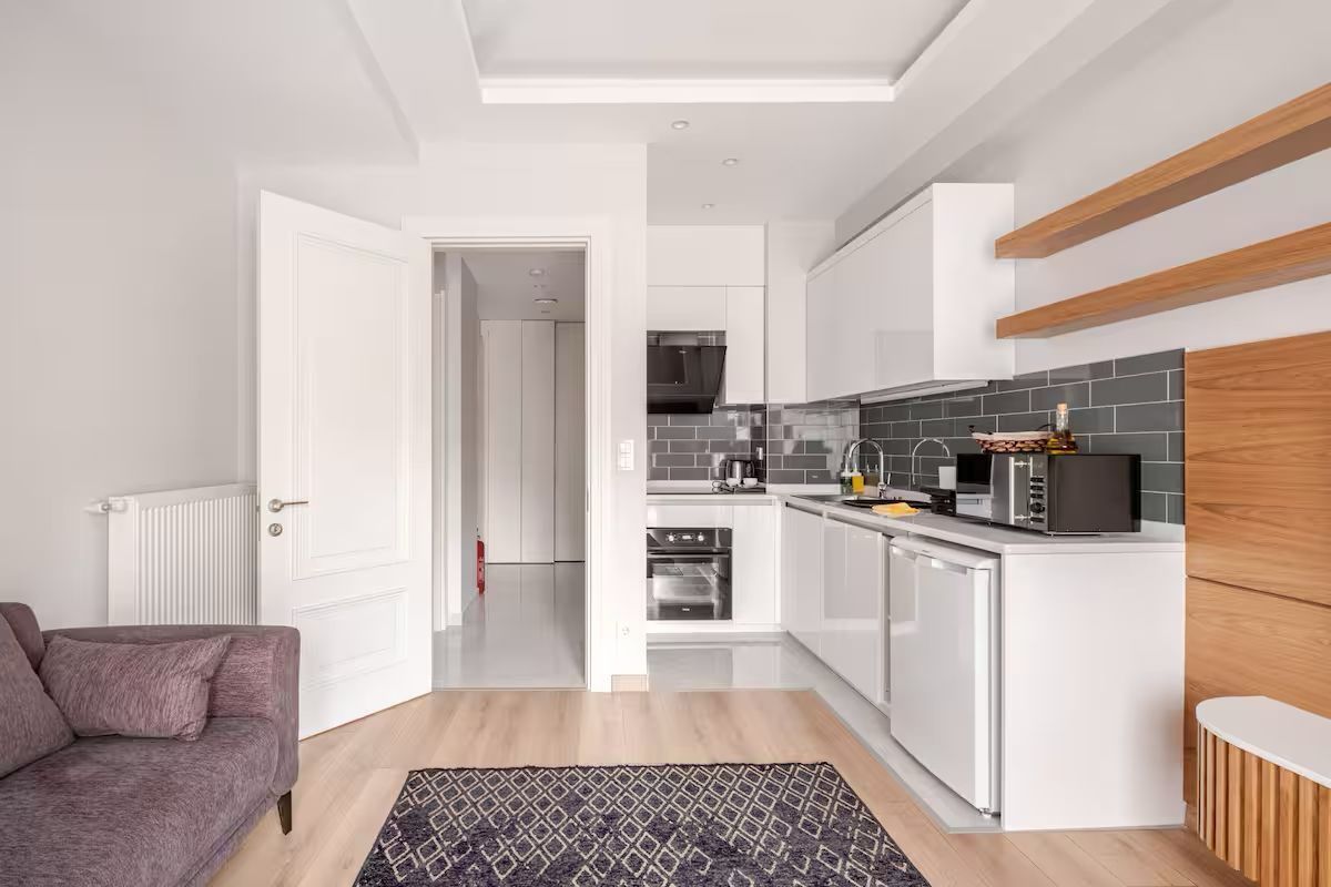 A living room with a couch , rug , and kitchen.