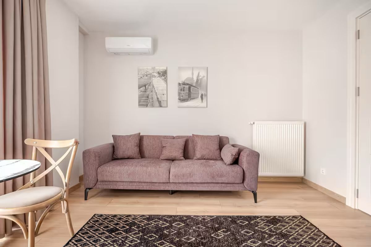 A living room with a couch , chair , table and rug.