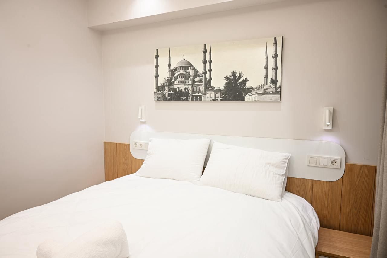 There is a picture of a mosque on the wall above the bed.