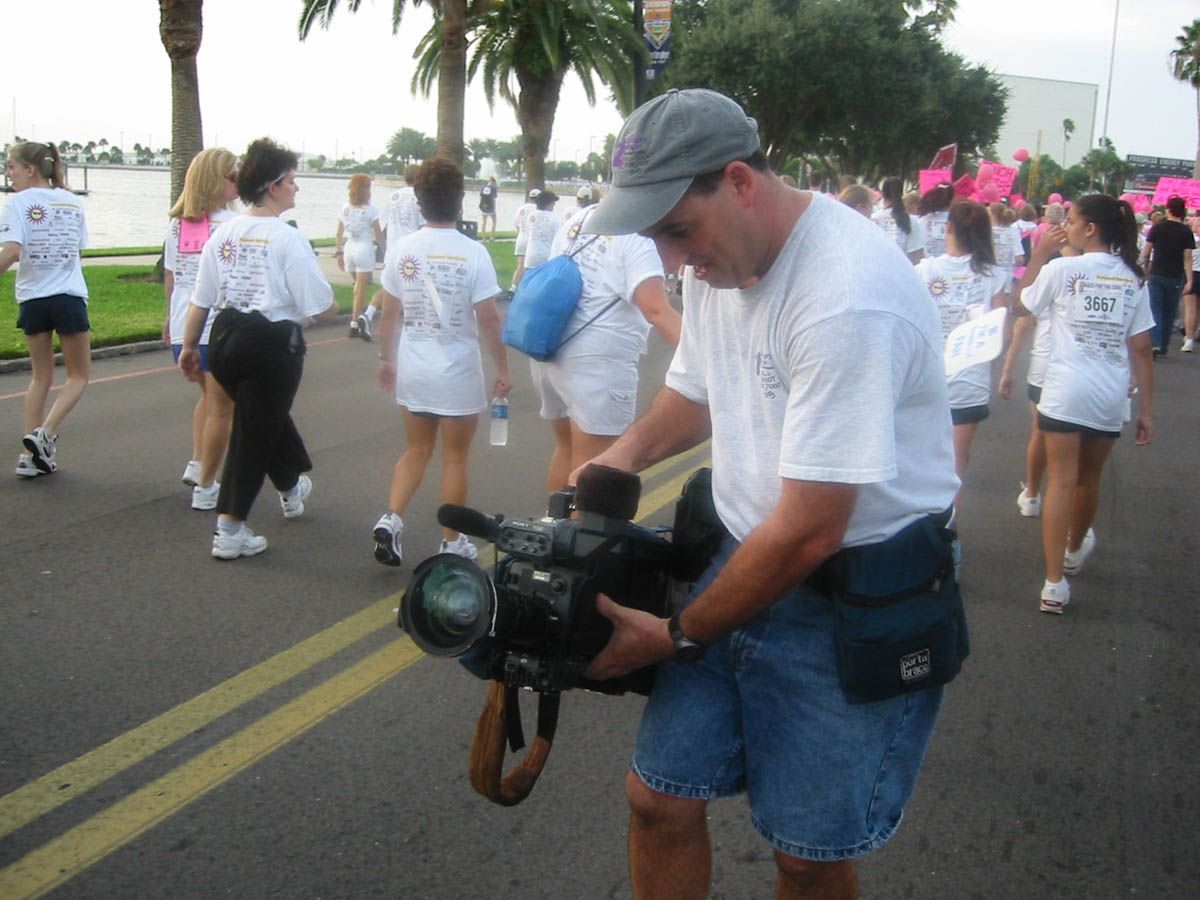 A man is holding a camera in front of a group of people