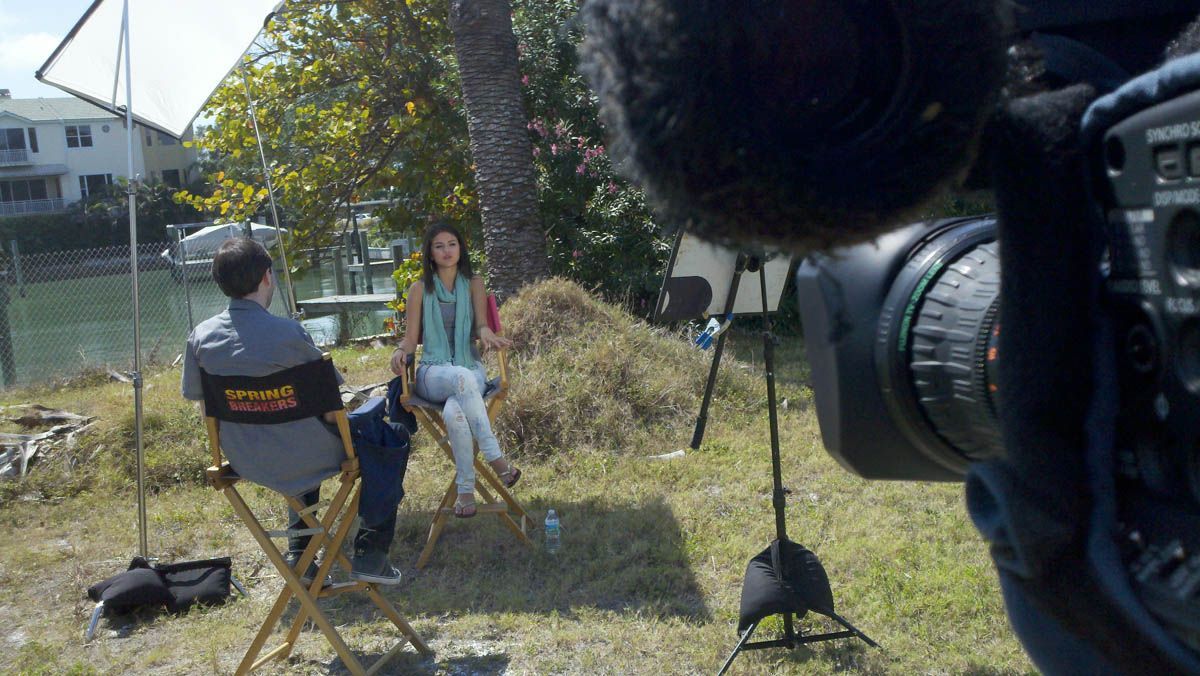 A man and a woman are sitting in chairs in front of a camera.