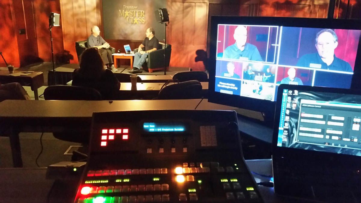 A group of people are sitting at tables in a room with a sign that says ' hollywood studio ' on it