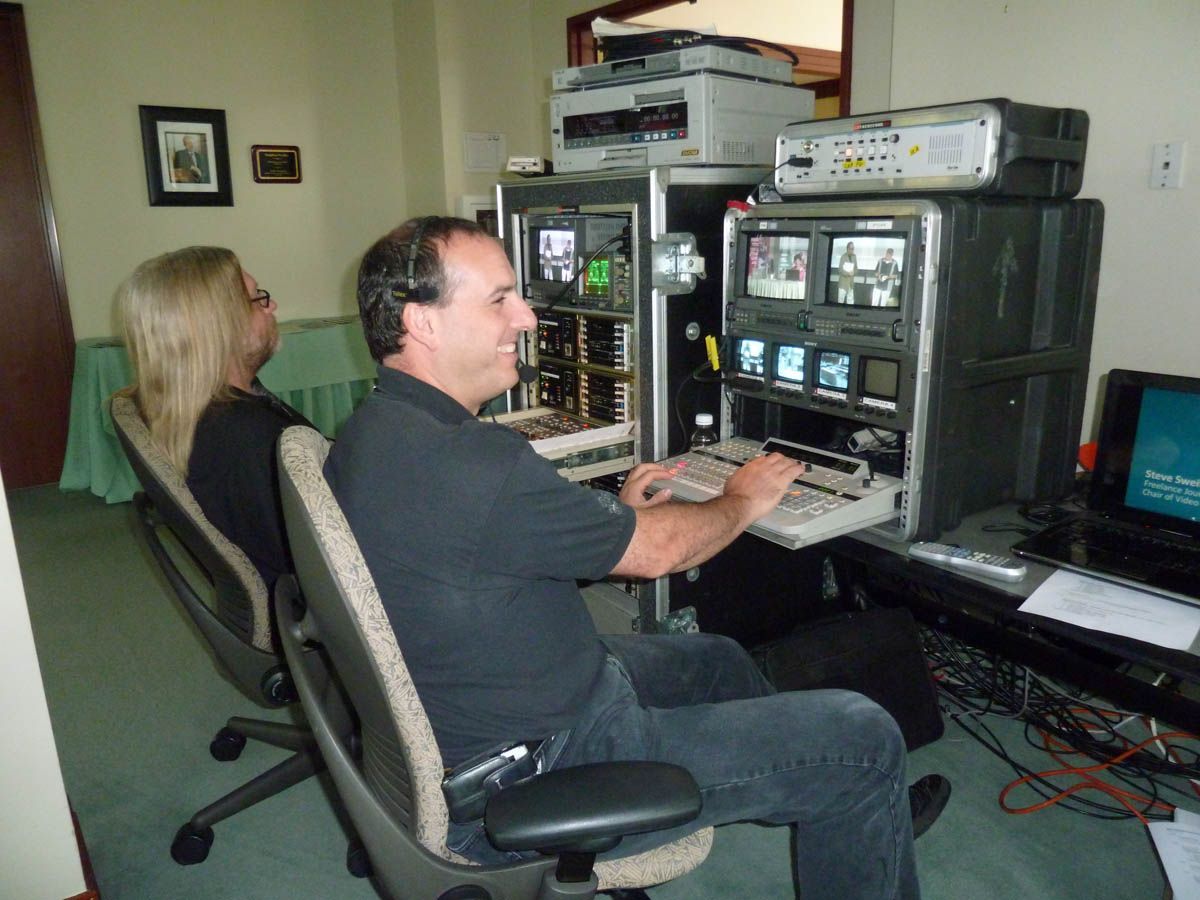 A man and a woman are sitting in front of a computer