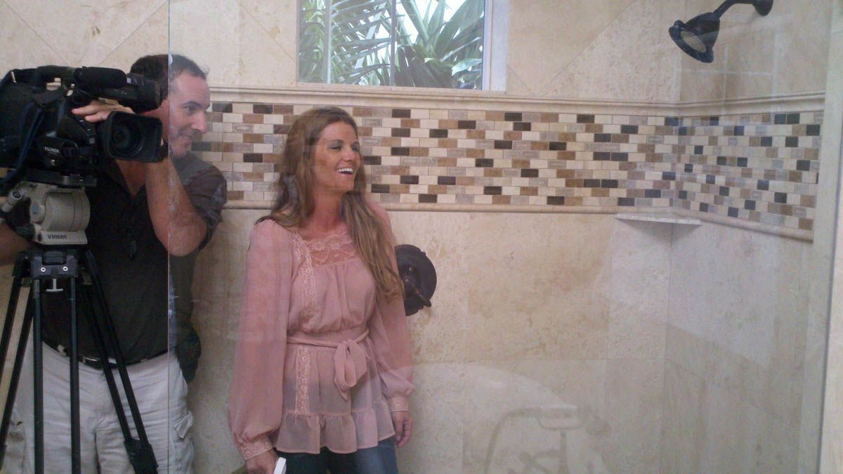 A man is taking a picture of a woman in a shower.