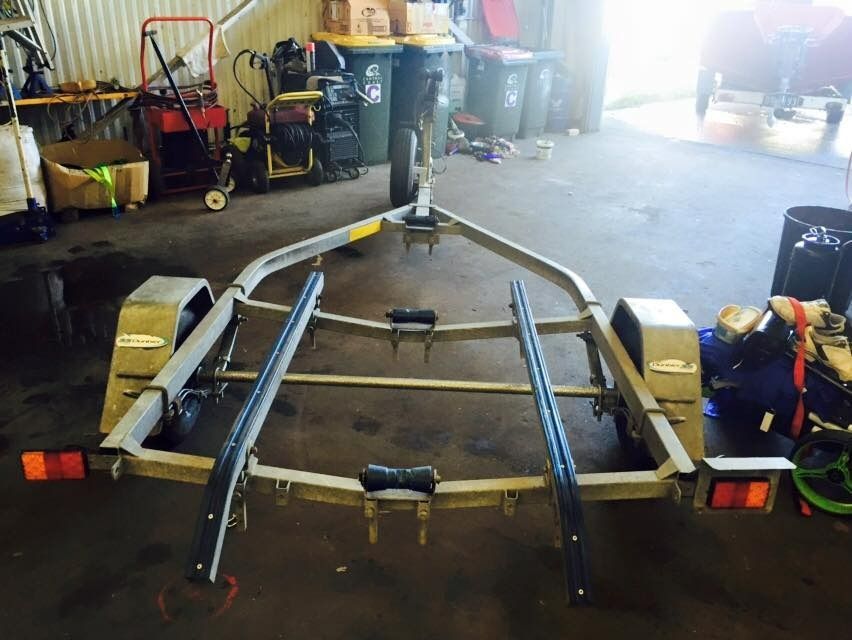 A Boat Trailer Is Sitting in A Garage Next to Trash Cans — Don's Marine Repairs in Woy Woy, NSW