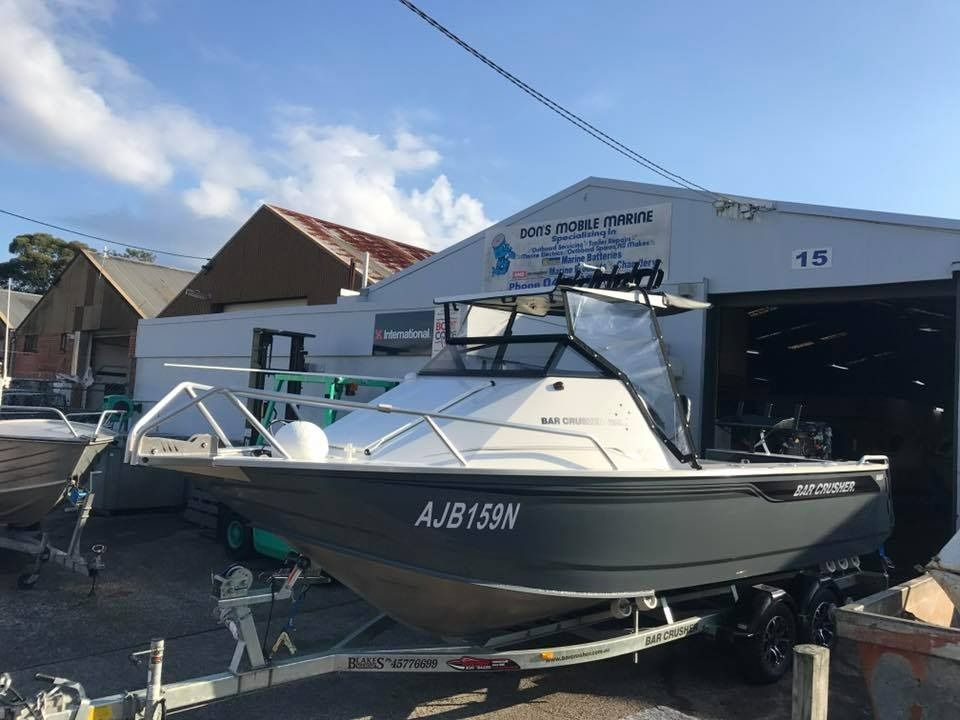 A Boat on A Trailer Is Parked in Front of A Building — Don's Marine Repairs in Woy Woy, NSW