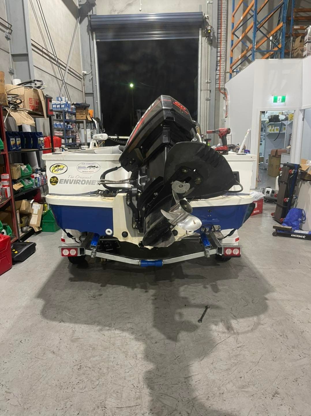 A Boat with A Motor Is Parked in A Garage — Don's Marine Repairs in Brisbane Waters, NSW