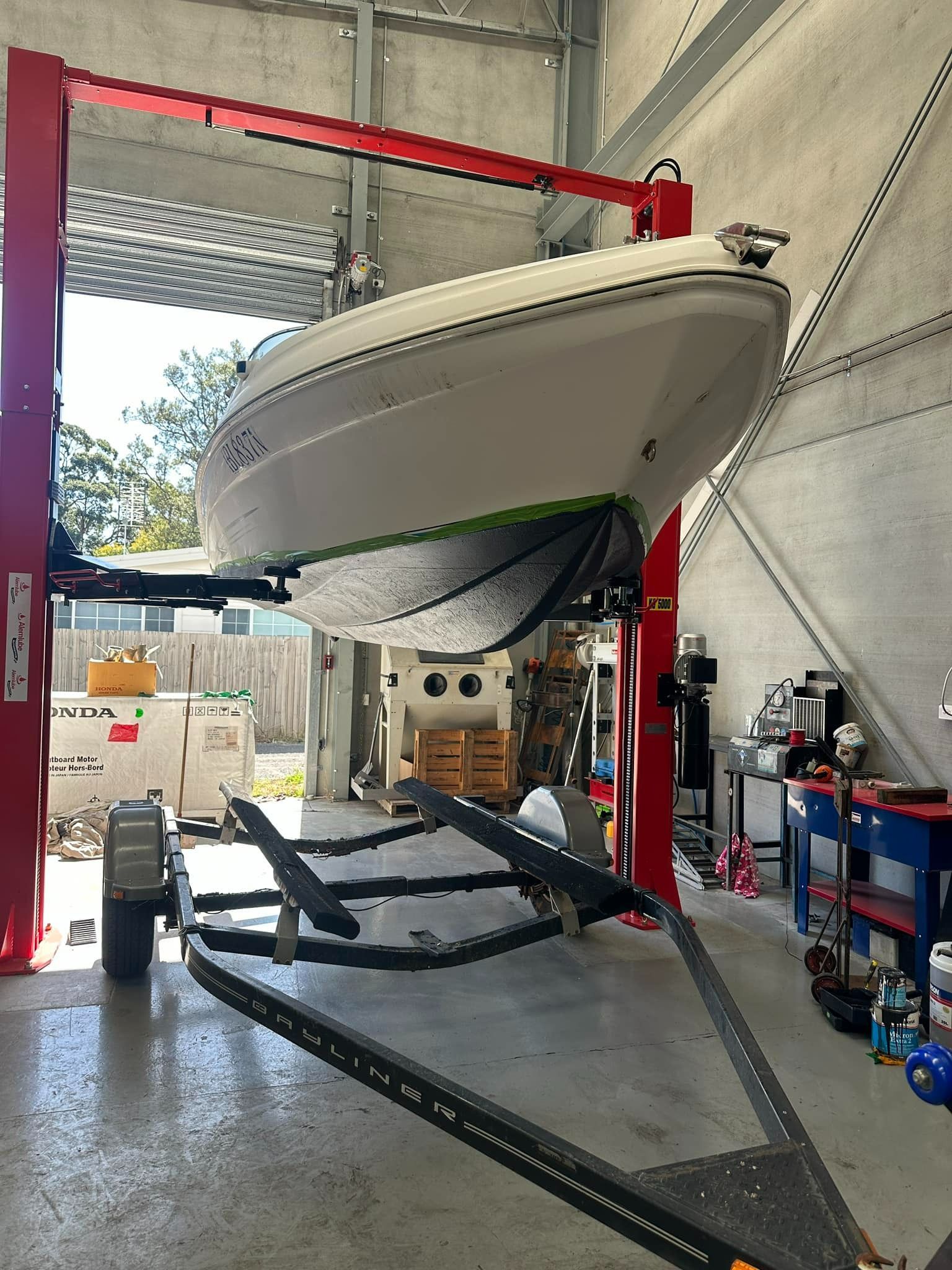 A Boat Is Sitting on A Lift in A Garage — Don's Marine Repairs in Umina, NSW