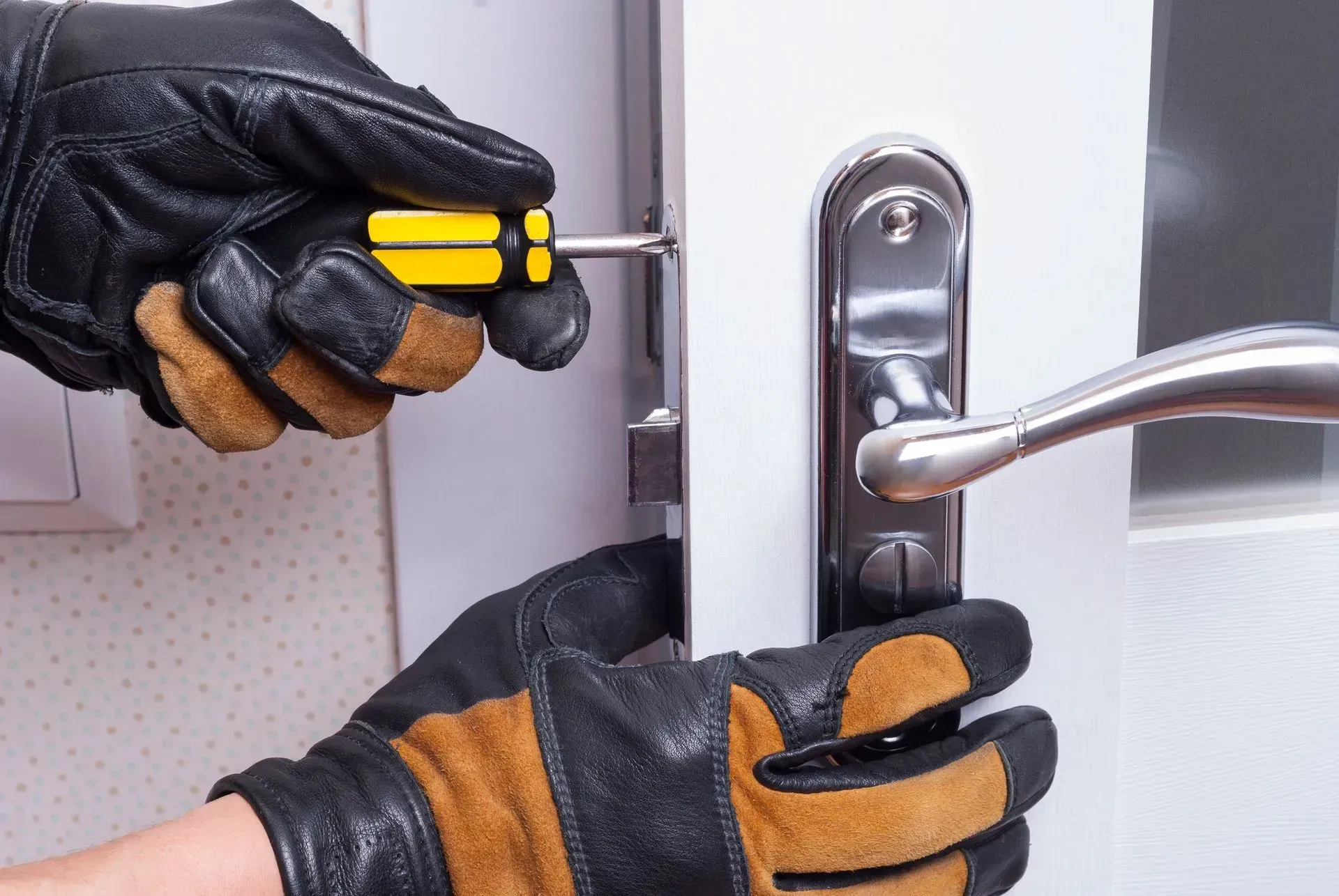 Expert locksmith technician handling precise door lock repair for improved home protection.