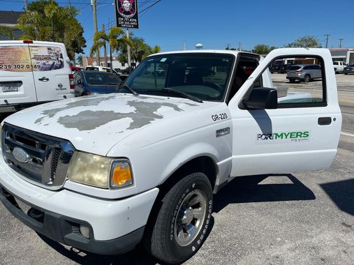 A white ford ranger truck is parked in a parking lot.