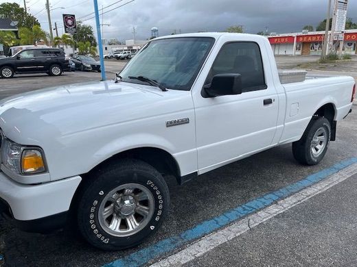 A white pickup truck is parked in a parking lot.