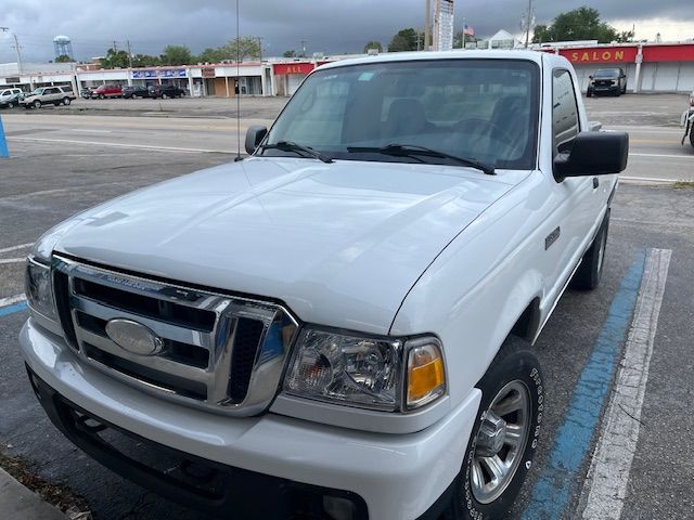 A white ford ranger truck is parked in a parking lot.