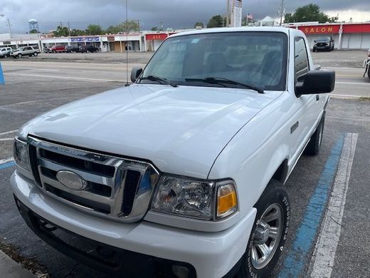 A white ford ranger truck is parked in a parking lot.