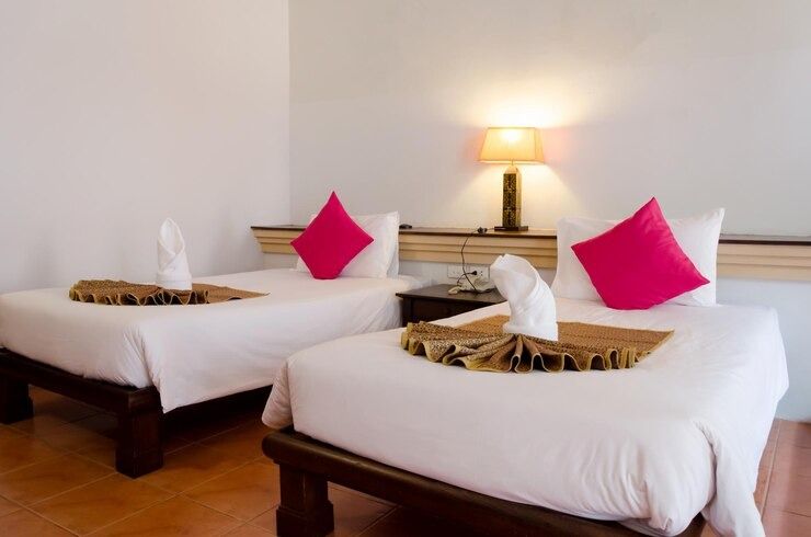 Una habitación de hotel con dos camas y una lámpara.