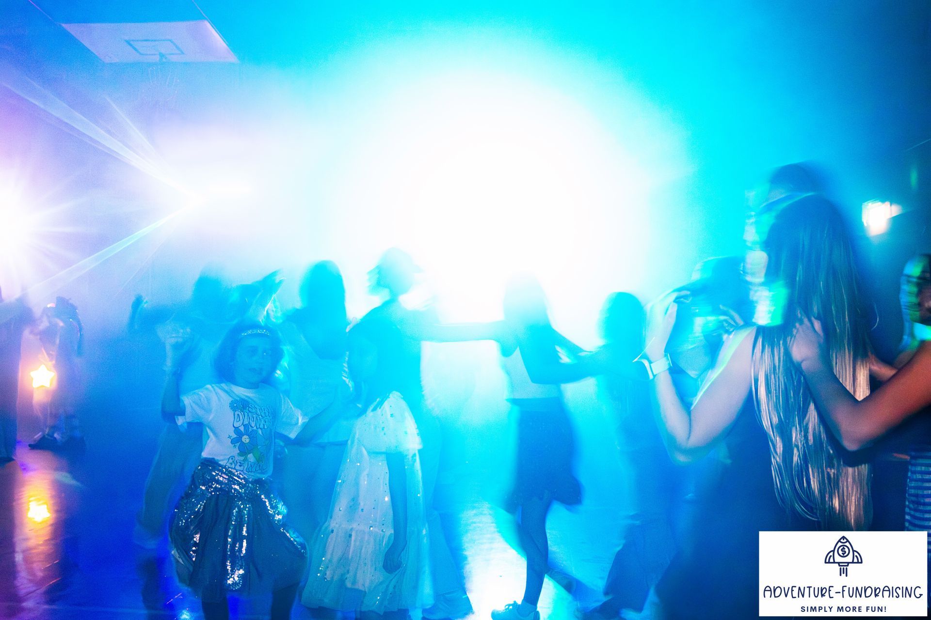 People dancing under bright blue stage lights.