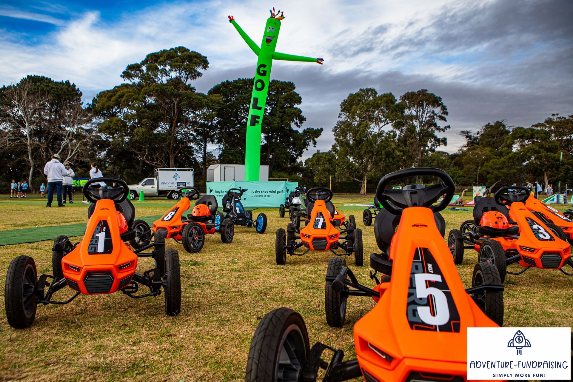 Orange go-karts numbered 1-7 on a green field, with a green 