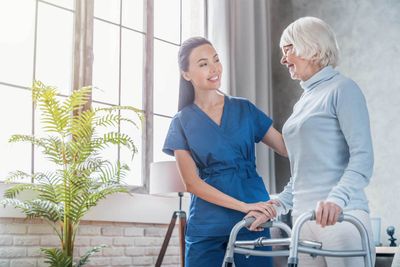Female Helping Senior Woman to Walk with Walker — St. Paul, Minnesota — Care Plus HHA
