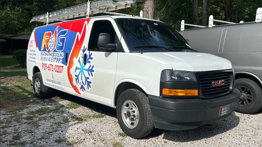 White GMC van with a colorful logo for an air conditioning and heating service, parked outdoors.