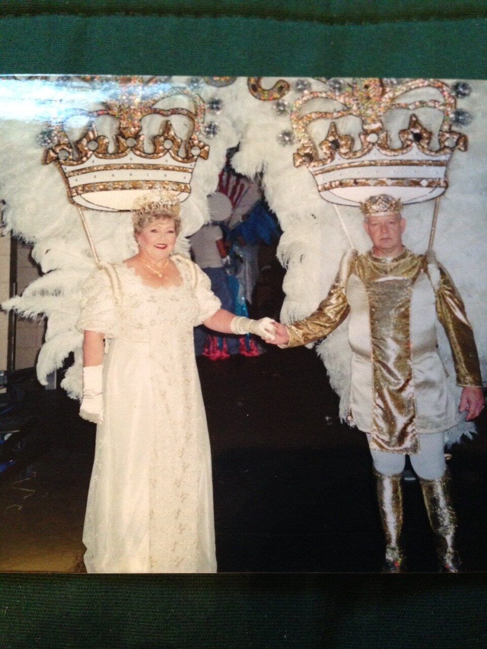 A woman in a white dress stands next to a man in a gold costume