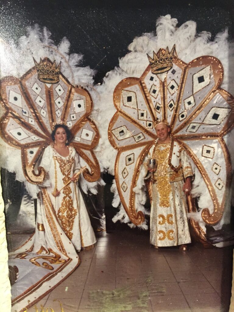 A woman in a peacock costume is standing next to a man in a peacock costume