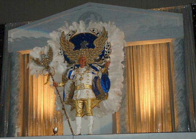 A man in a fancy costume is standing in front of a building