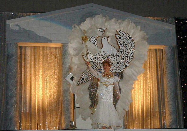 A woman in a white dress with feathers on it