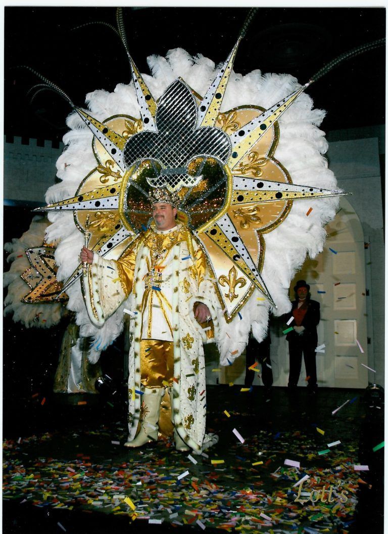A man in a carnival costume is standing on a stage