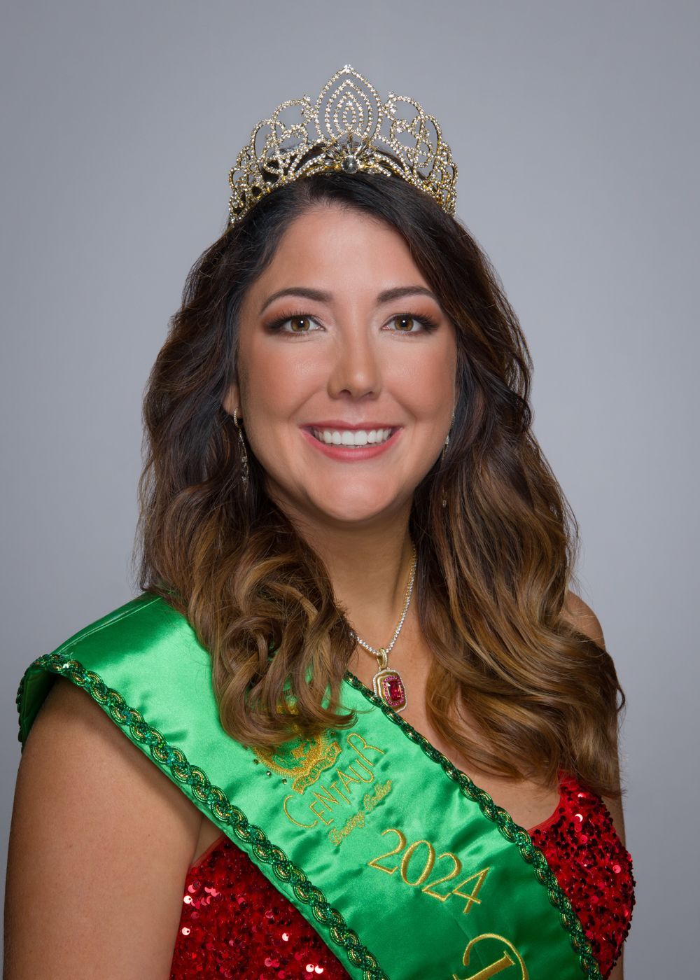 A woman is wearing a green sash and a tiara.