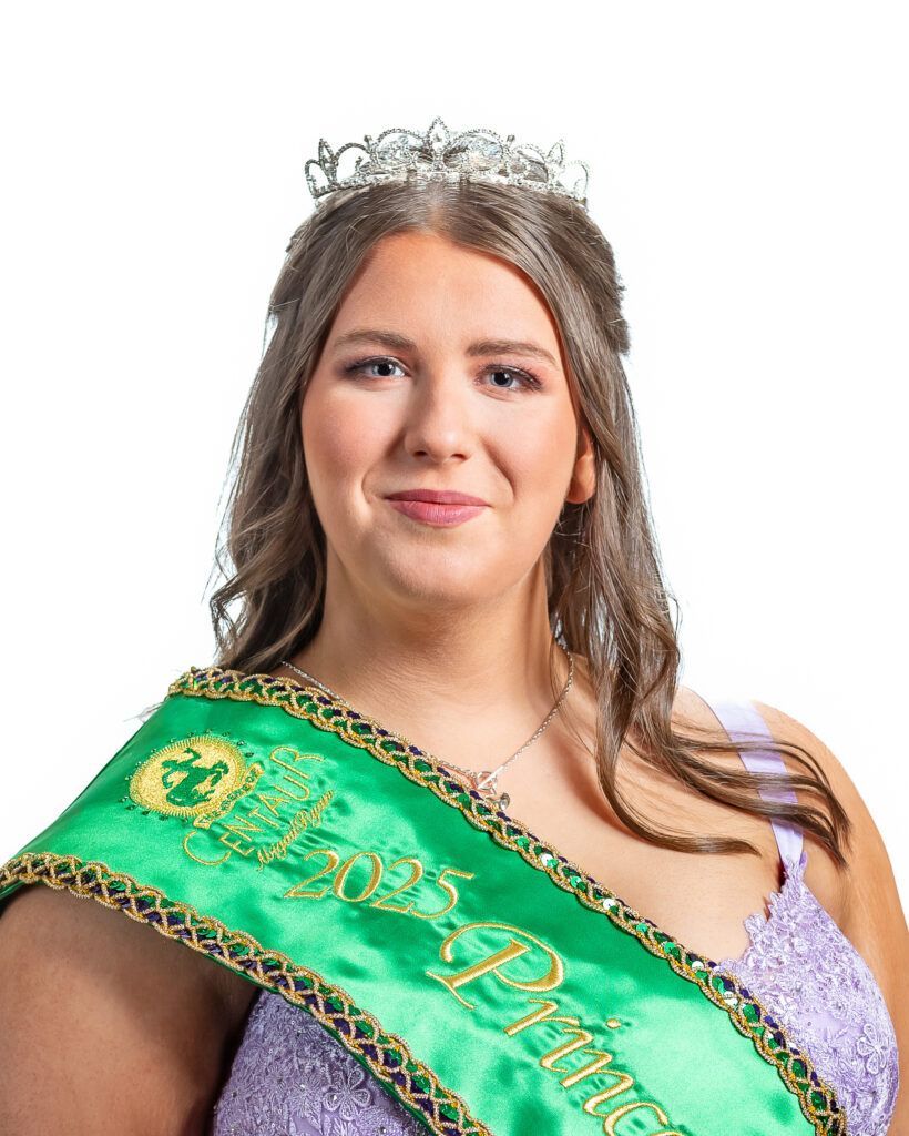 A woman in a purple dress is wearing a green sash and a tiara.