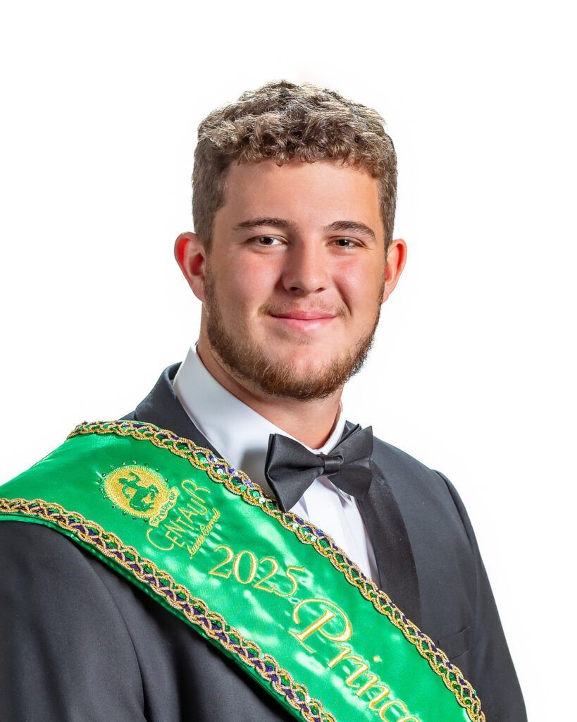 A man in a suit and bow tie is wearing a green sash that says ' prinz ' on it.